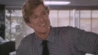 Robert Redford smiling, wearing a checkered shirt and tie