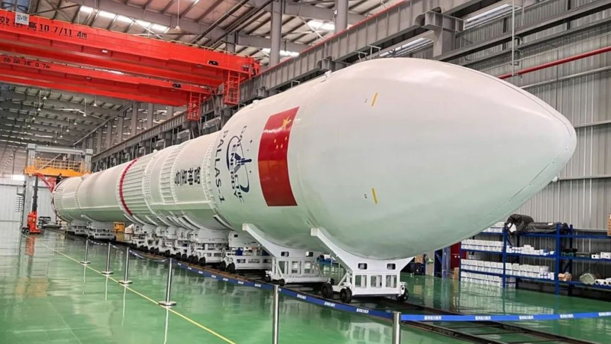 a large white rocket on its side in a factory