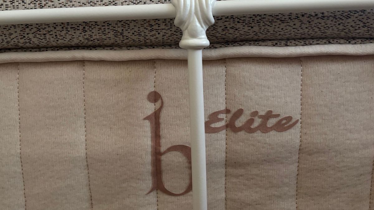 The beige Birch Elite Natural mattress placed on a white bedframe inside a mattress tester's neutrally decorated bedroom