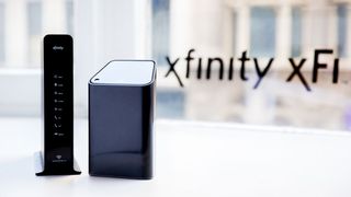 A pair of xFinity routers sitting in front of a window