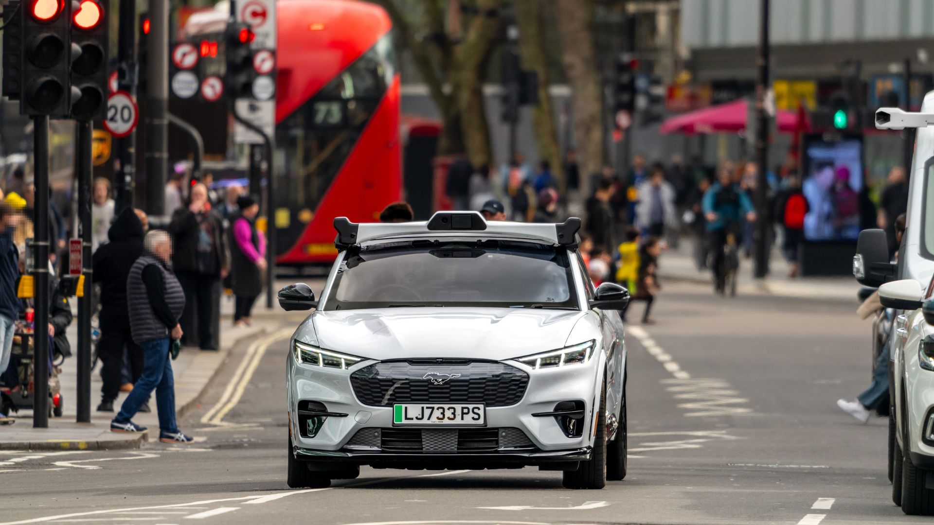 an image of a silver Ferrari which is part of Wayve's test fleet fot auto-driven cars. The car is driving through London on a fairly quiet road