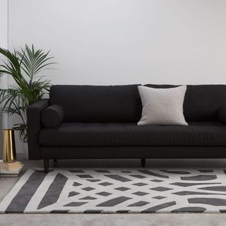 whit living room with black sofa and carpet floor