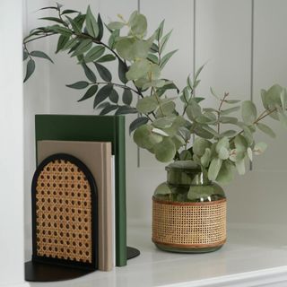 A green glass vase with rattan details