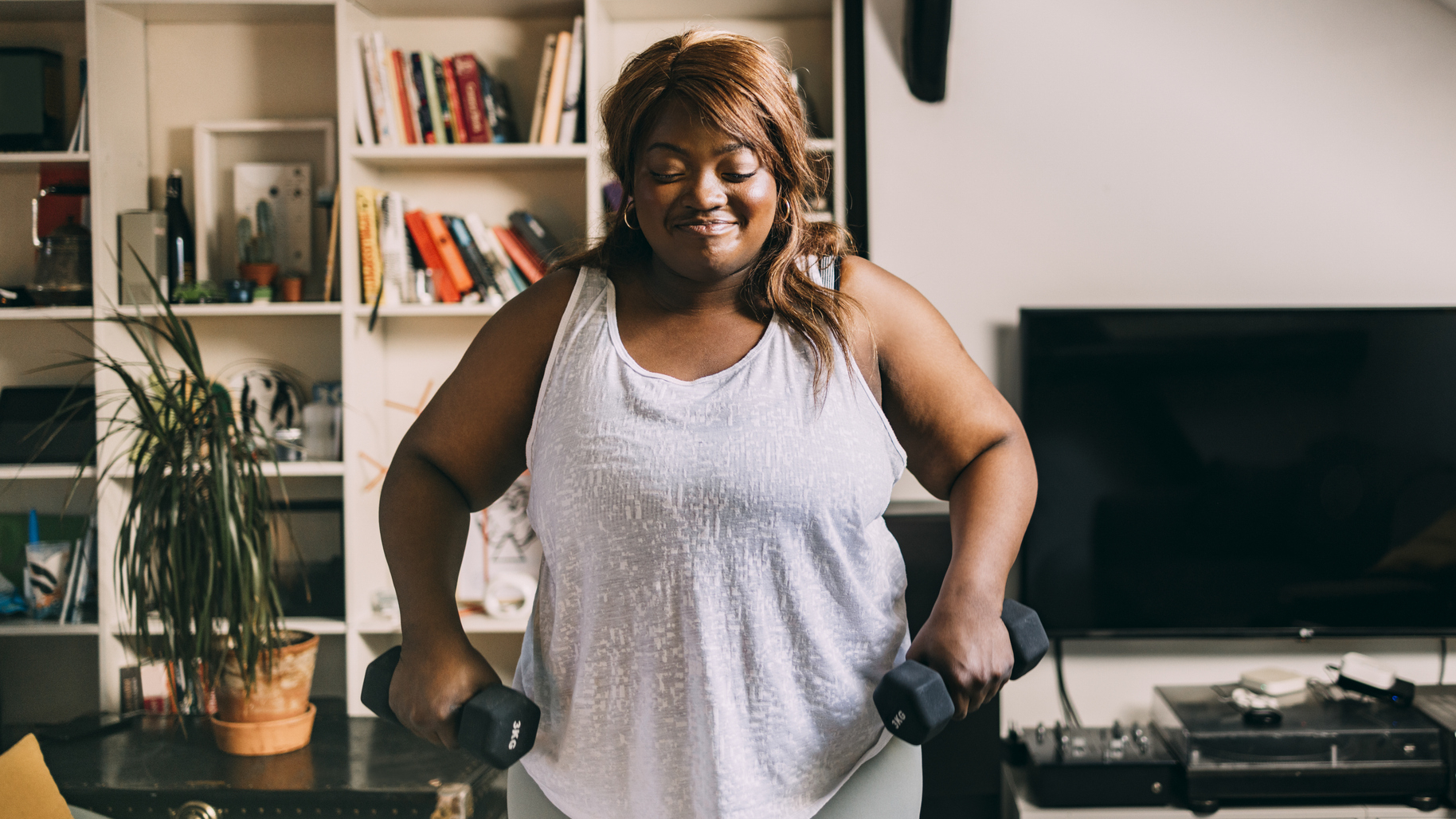 Woman exercising at home with dumbbells