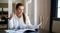 Confident woman analyzing paperwork at home