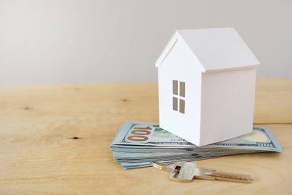 Rendering of a model house on a pile of US currency