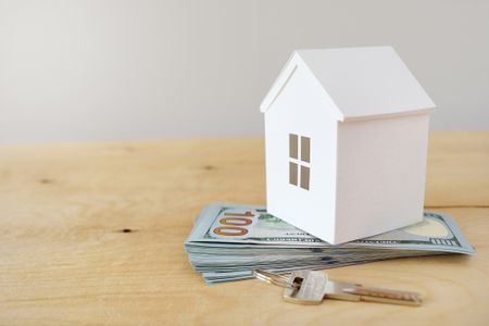 Rendering of a model house on a pile of US currency