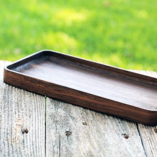 A dark wood carved counter tray