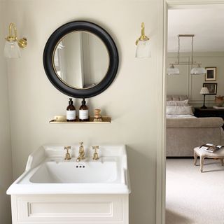 Ensuite bathroom with round mirror and rustic vanity lighting