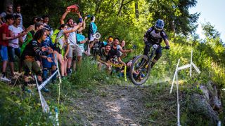 Crowd cheering on a rider on a track in an enduro race