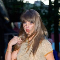 Taylor Swift wearing a beige cashmere polo shirt, blue jeans, tan belt, tan shoulder bag, and tan Gucci sandals