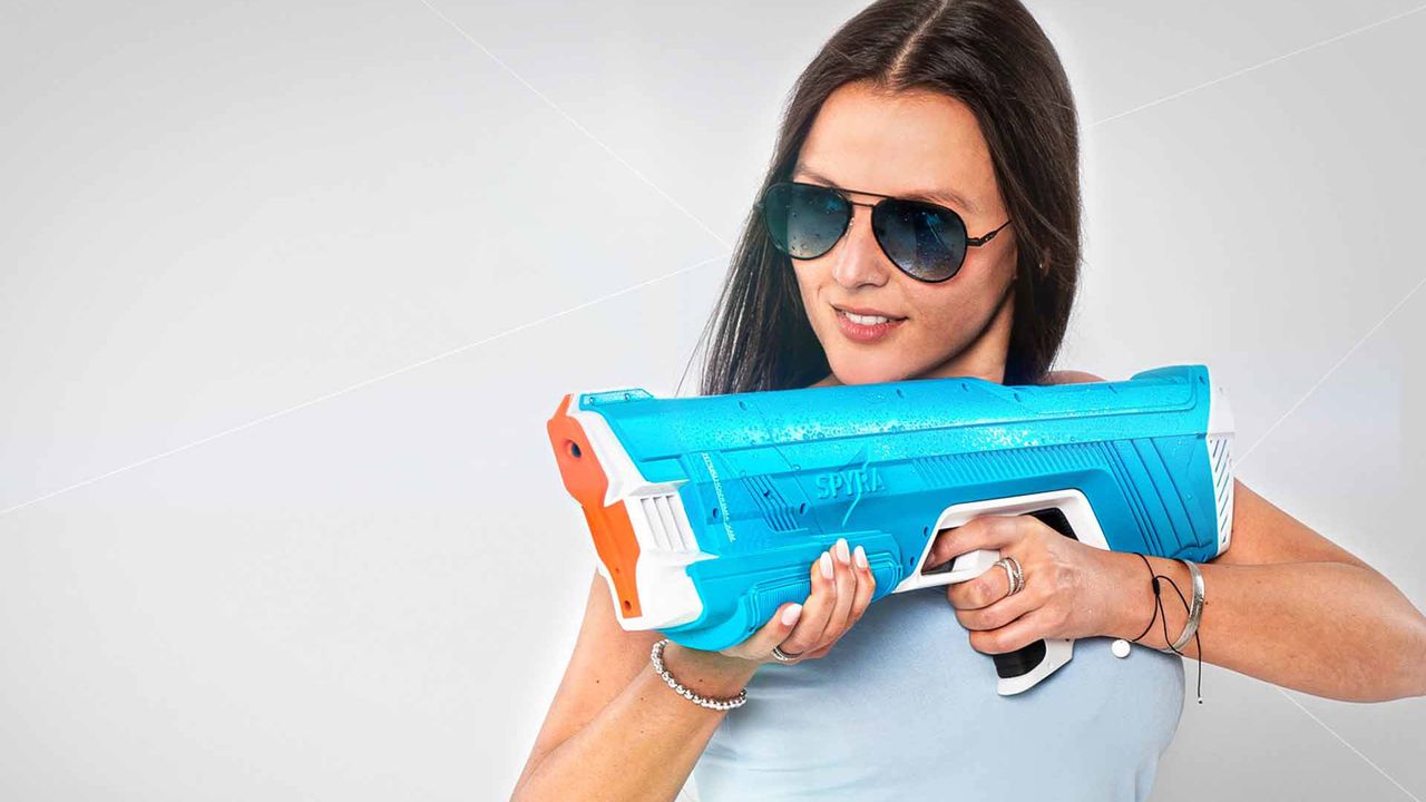 SpyraTwo water gun in blue colorway being held by an adult woman wearing sunglasses