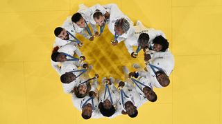 An overview shows French national judo team posing after winning the judo mixed team gold medal bout between Japan and France at the Paris 2024 Olympic Games in the Champ-de-Mars Arena, in Paris on August 3, 2024. (Photo by Martin BUREAU / AFP) (Photo by MARTIN BUREAU/AFP via Getty Images)