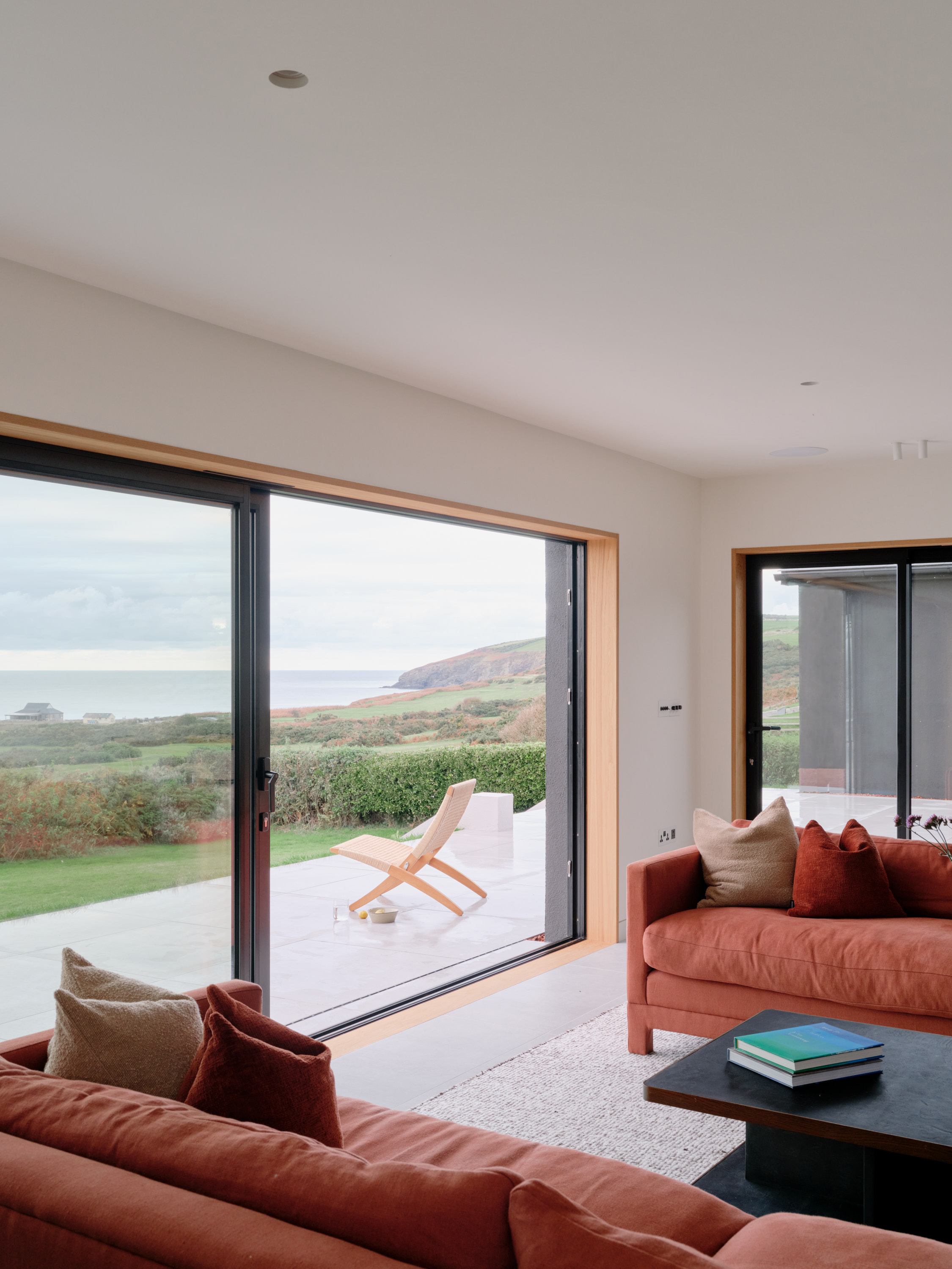 view of a welsh cottage or bungalow type building facing the sea and redesigned in a fairly minimalist, contemporary way