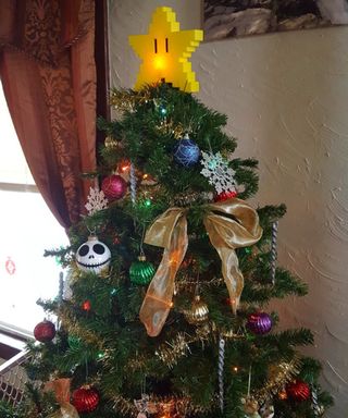 Super Mario Starman Yellow Star Christmas topper on top on decorated artificial Christmas tree