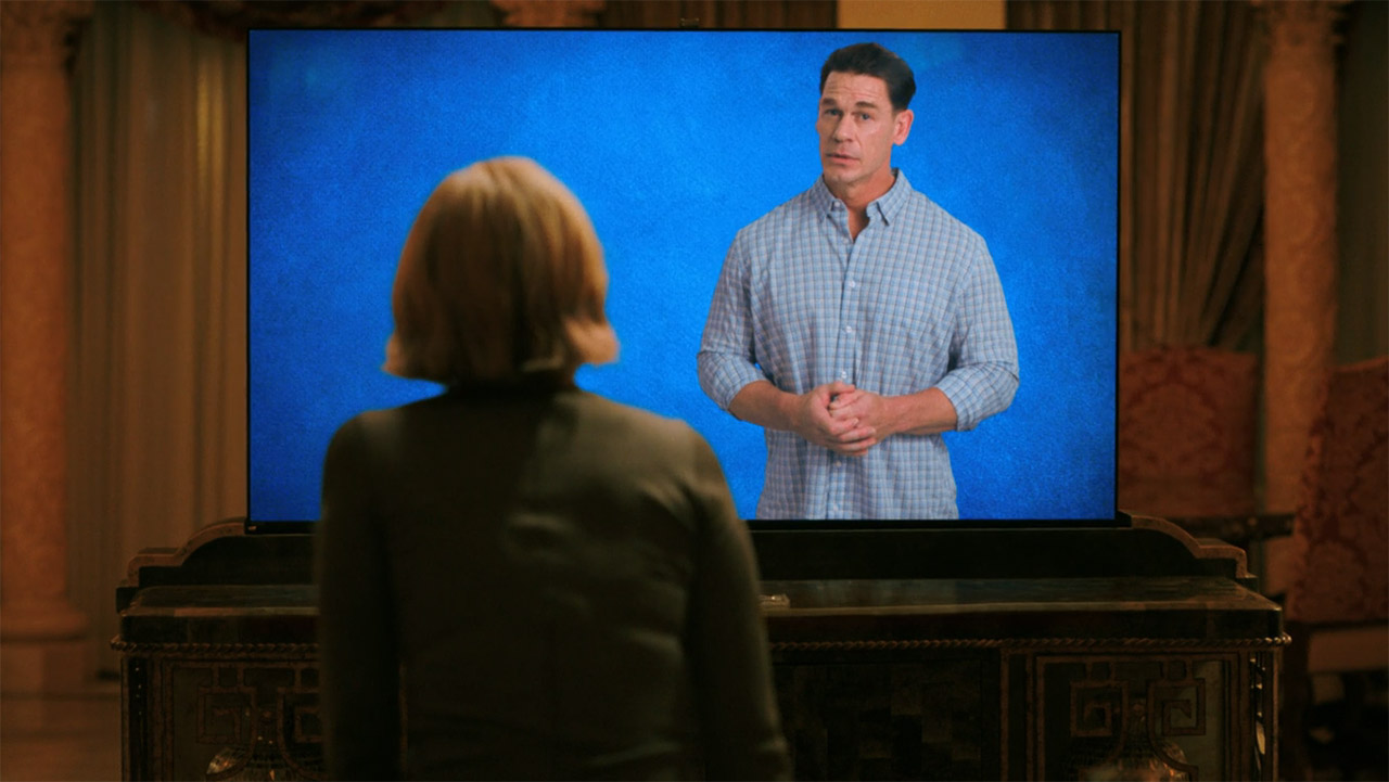 Carol looking at John Cena on a TV in Pluribus episode 6