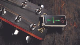 A TC Electronic PolyTune Clip on the headstock of a Martin acoustic guitar