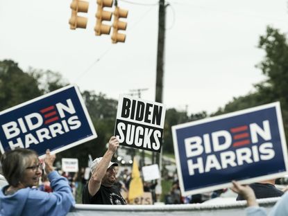 Pro-Biden and Pro-Trump supporters hold signs ahead of U.S. President Joe Biden's arrival in Howell, Michigan, in 2021
