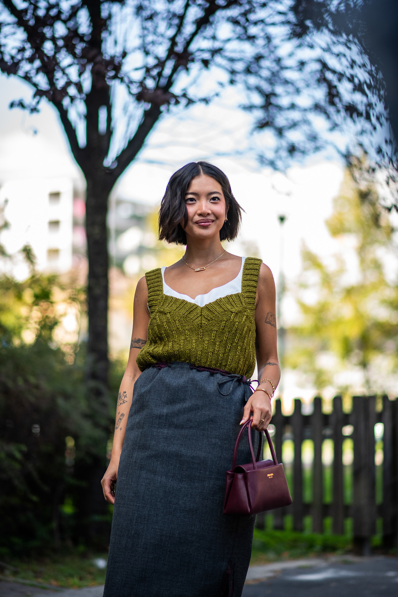 an asian woman with a brown bob in a green knit tank top and skirt