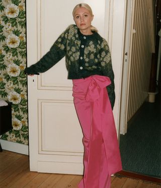 Woman wearing brown knit cardigan and pink long skirt