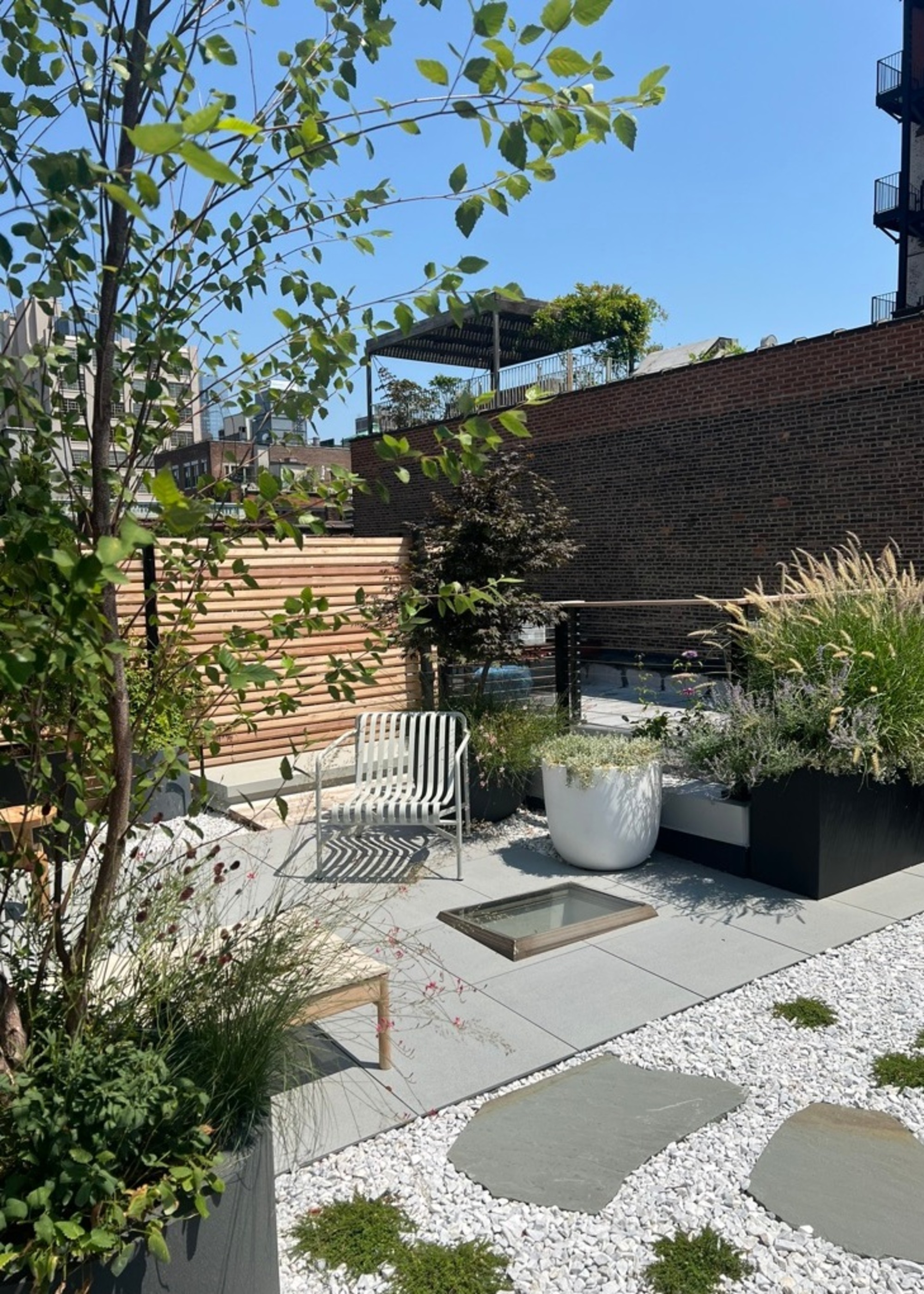 trees and plants on a balcony with a timber fence