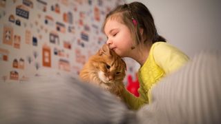 Little girl cuddling cat