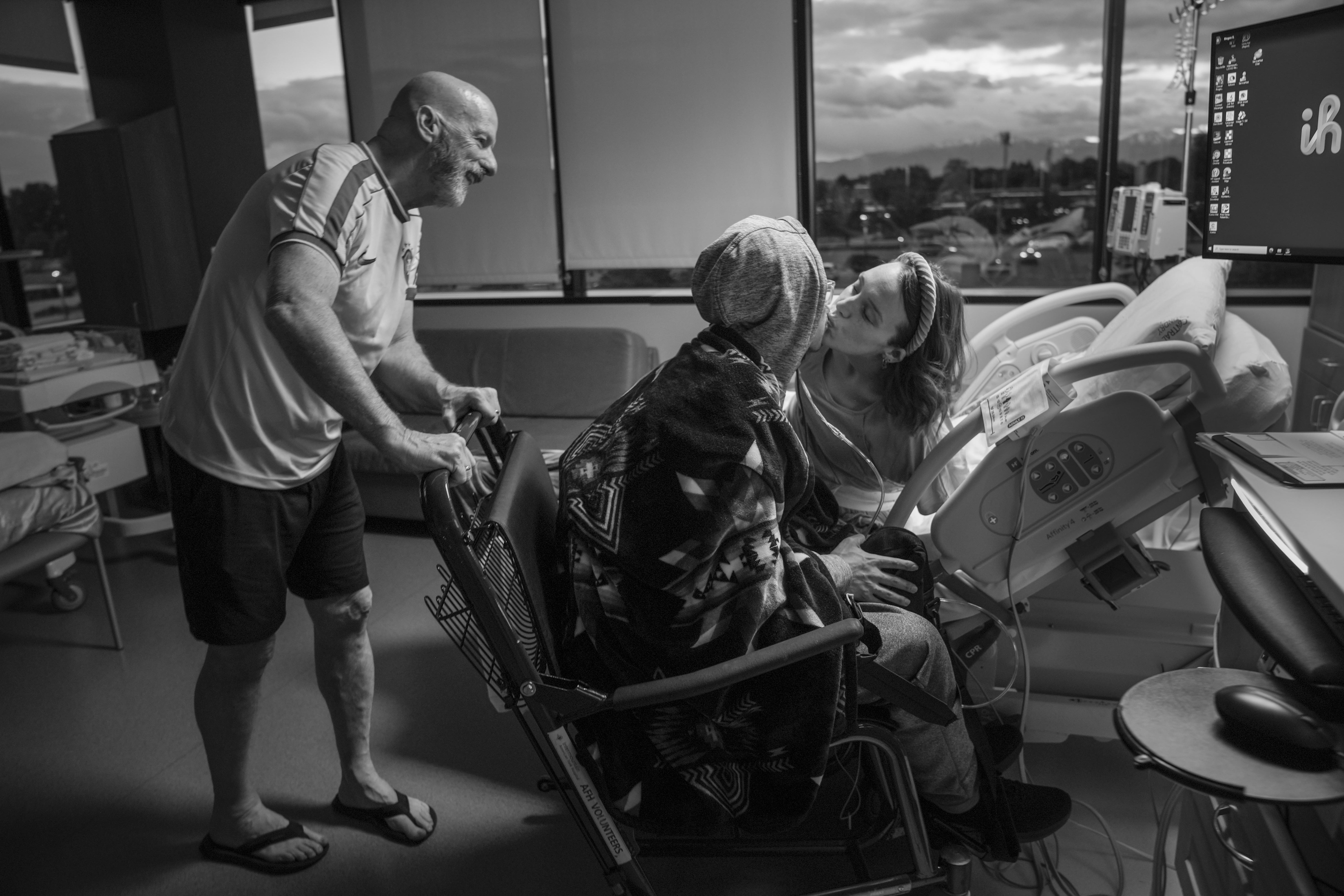 Shay Martin, 29, R, bids farewell for the night to her cancer-ridden husband, Tanner Martin, 30, as she prepares to give birth to their child the next morning.