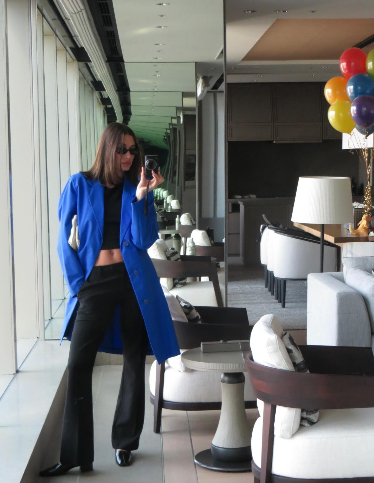 Hailey Bieber wears a coat with pants and the Reformation Inez Pumps.