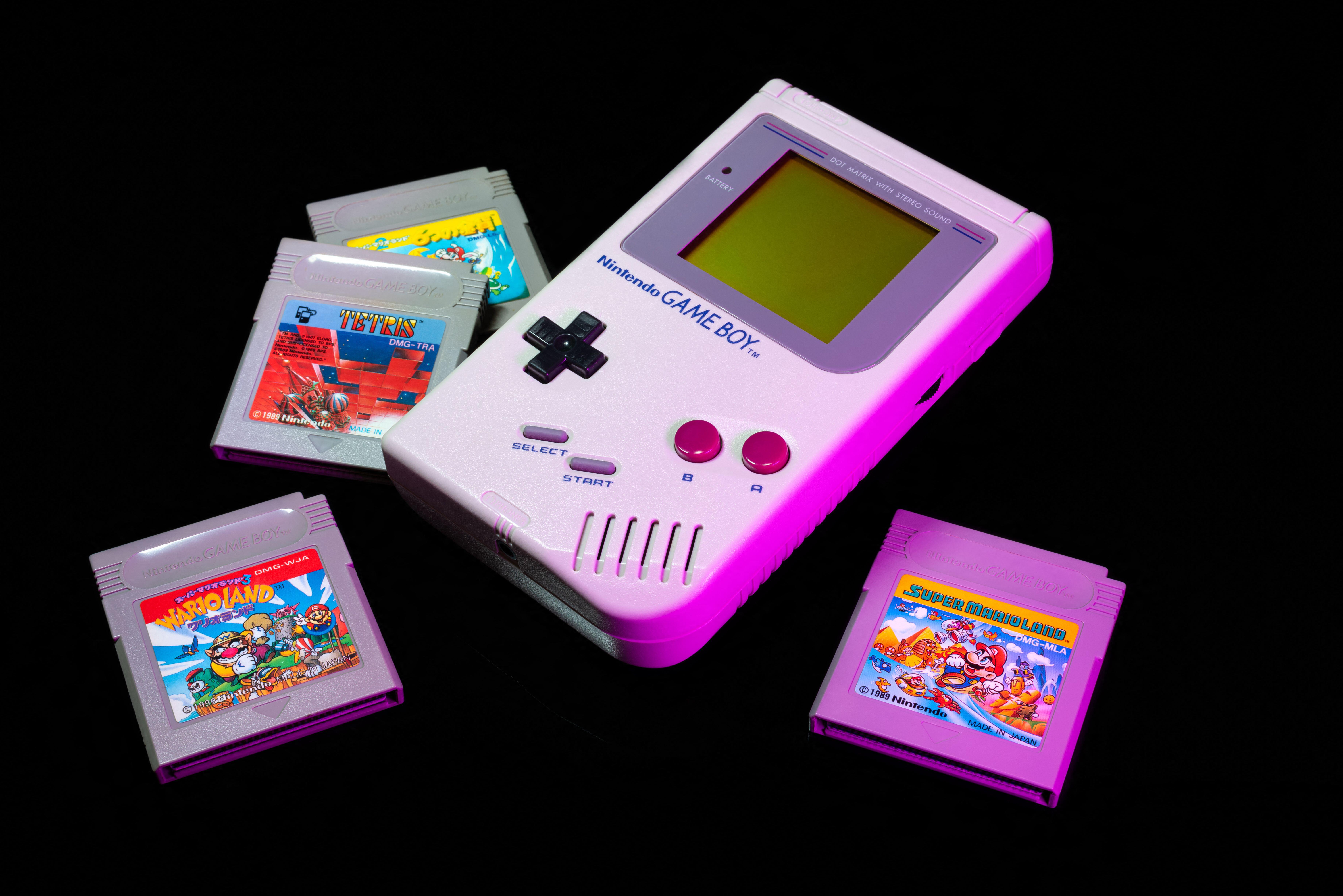 nintendo game boy and game boy color with various game cartridges isolated on black background