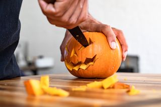 pumpkin being carved with a sharp knife