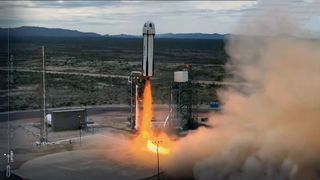 a white with black markings rocket lifts off from its West Texas launch site, climbing into an overcast sky.