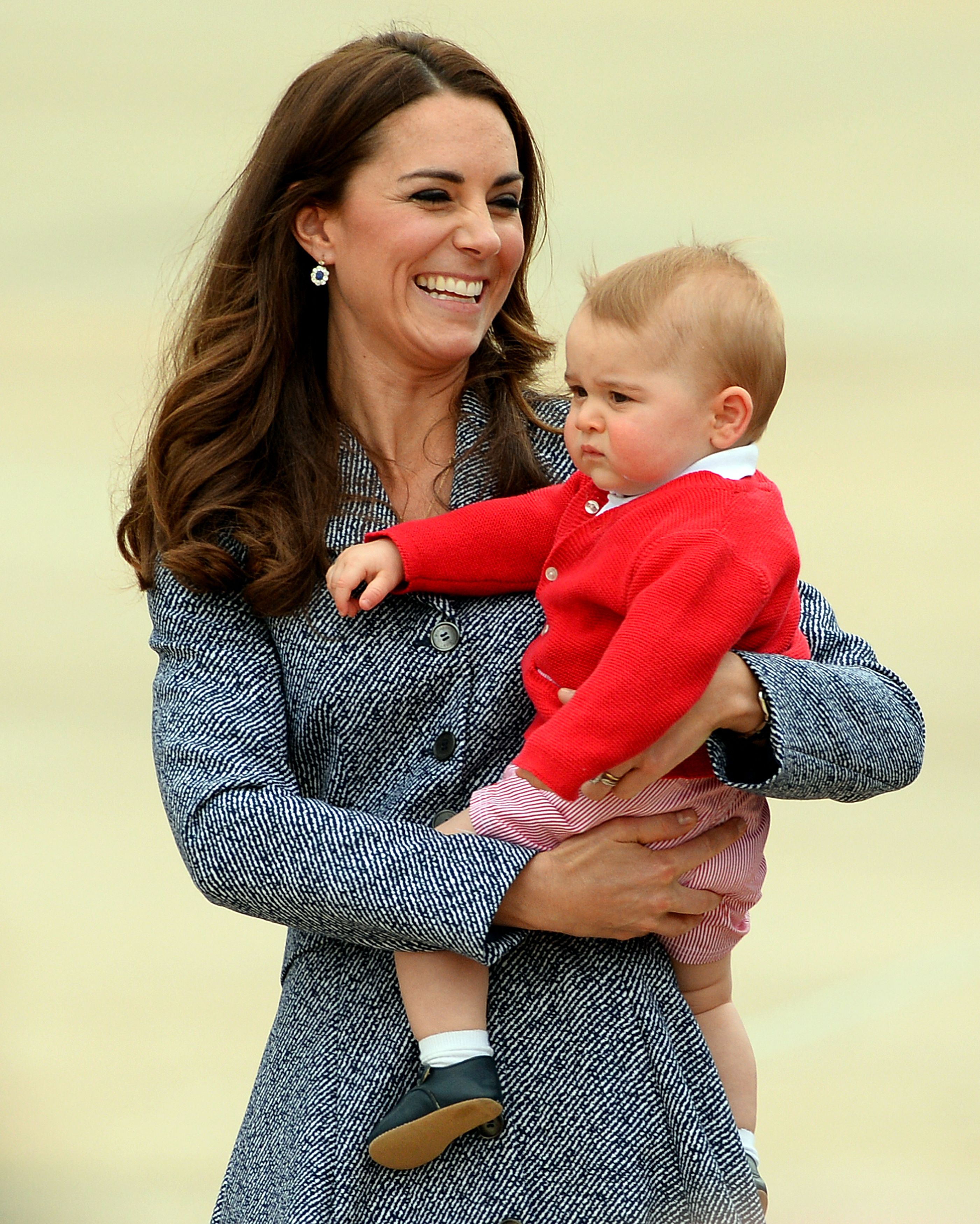 Catherine, the Duchess of Cambridge, walks with her son Prince George at the Defence Establishment Fairbairn in Canberra on April 25, 2014.