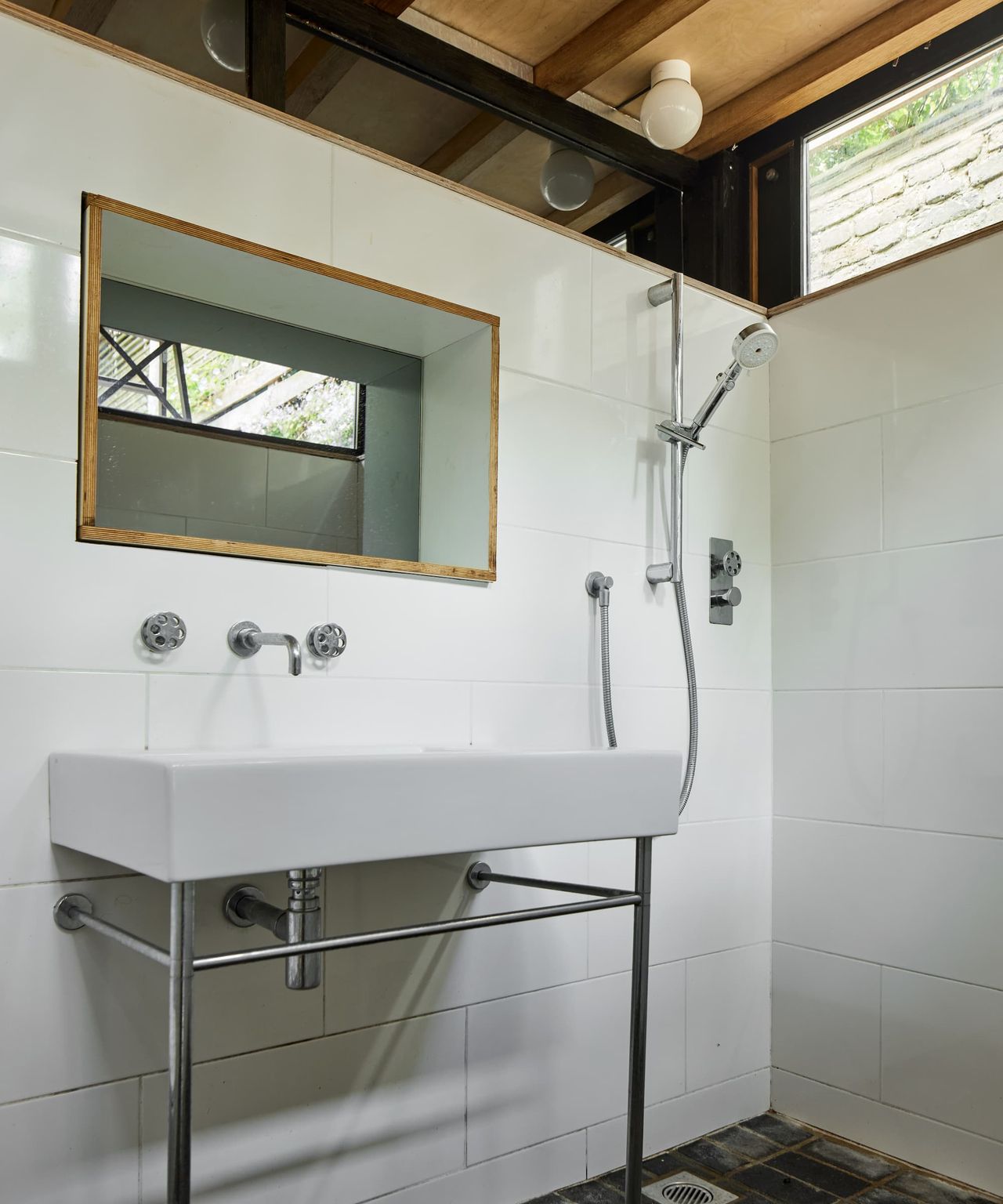 A bathroom with a large white sink and wooden beamed ceiling
