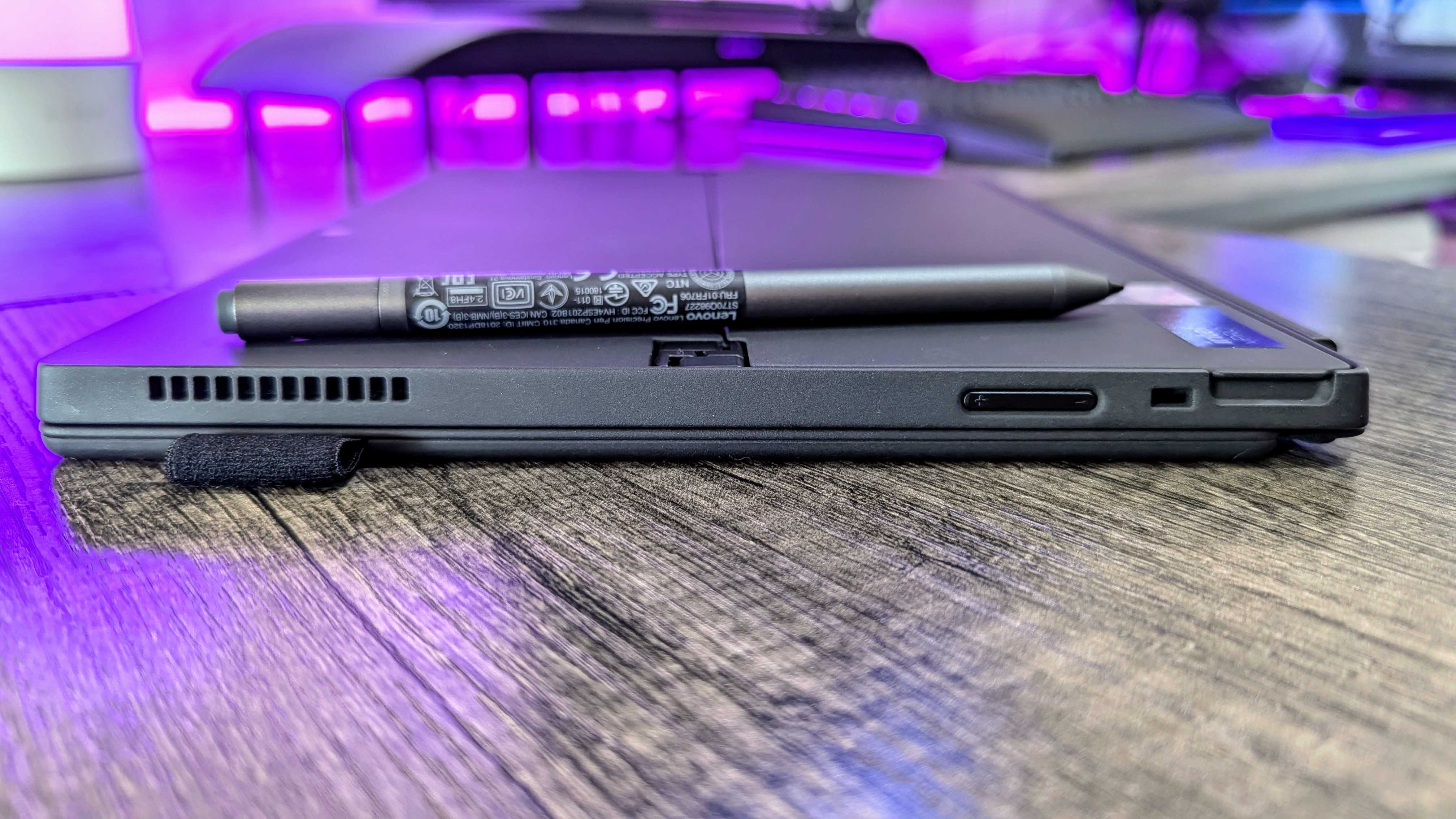 The Lenovo ThinkPad X12 Detachable (Gen 2) lying flat on a desk, showing the side ventilation, volume rocker, and Kensington Nano lock slot.