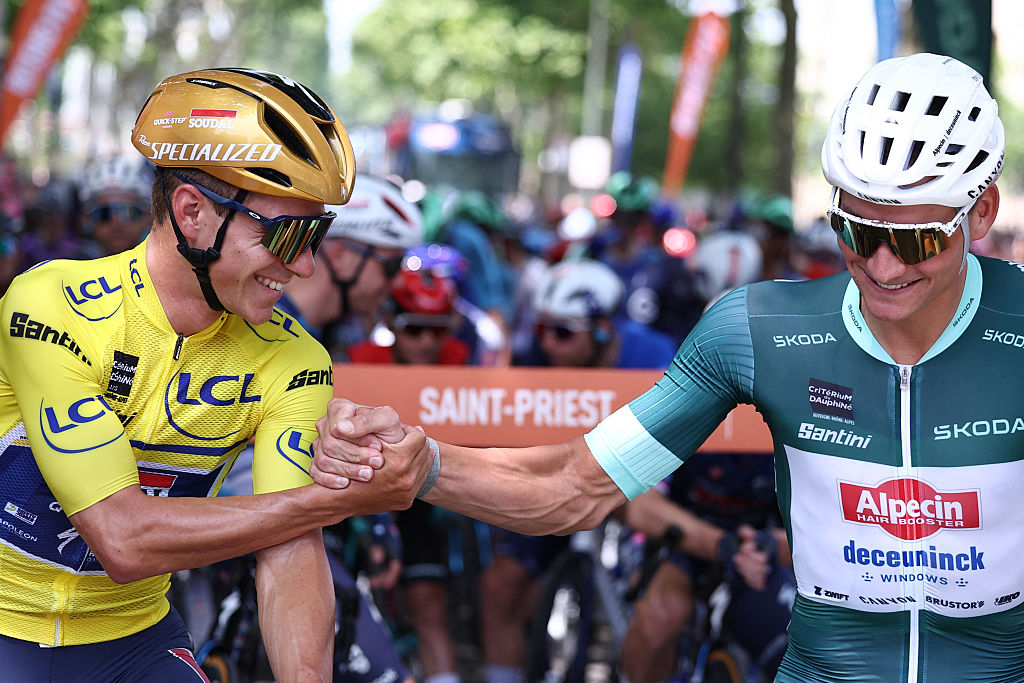 Soudal Quick-Step's Belgian rider Remco Evenepoel wearing the overall leader's yellow jersey (L) shakes hands with Alpecin-Deceuninck's Dutch rider Mathieu van der Poel wearing the sprinter's green jersey during the 5th stage of the 77th edition of the Criterium du Dauphine cycling race, 183 km between Saint-Priest and Mâcon, on June 12, 2025. (Photo by Anne-Christine POUJOULAT / AFP) (Photo by ANNE-CHRISTINE POUJOULAT/AFP via Getty Images)