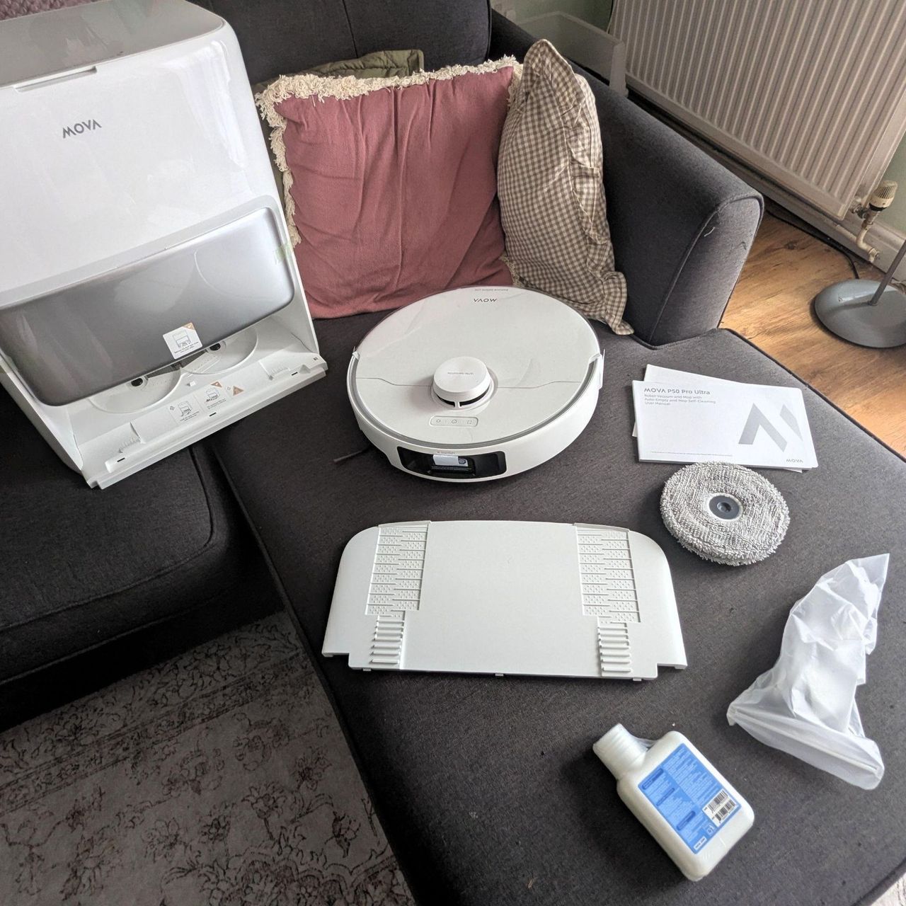 MOVA P50 Pro Ultra Robot Vacuum components laid out on a grey chaise sofa