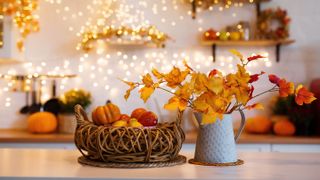 Fall décor including fallen leaves on display and pumpkins