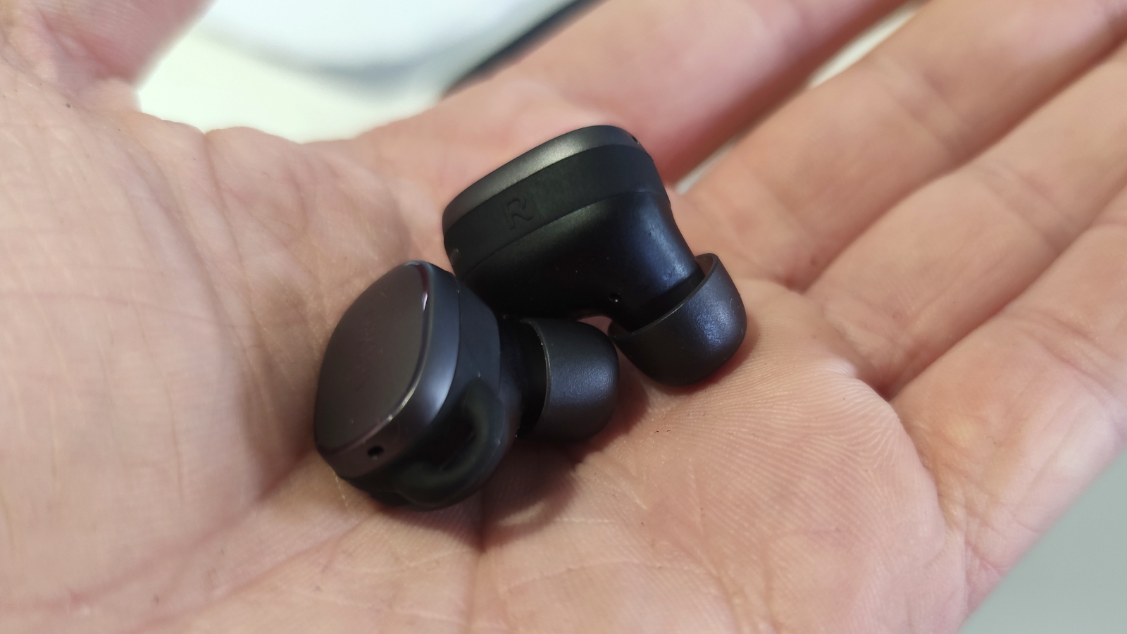 The Earfun Free Pro 3 buds in a hand.