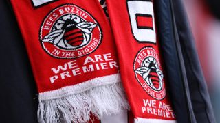 A fan of Brentford wears a scarf celebrating the teams promotion to the English Premier League during the Pre Season Friendly between Brentford v West Ham United at Brentford Community Stadium on July 31, 2021 in Brentford, England.