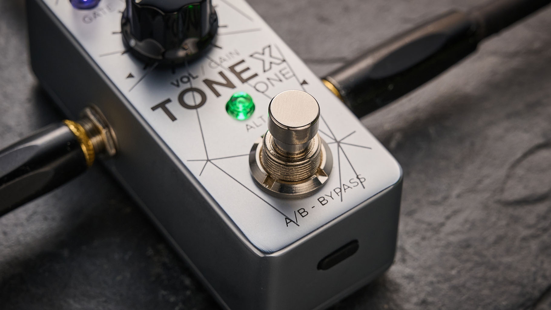 IK Multimedia Tonex One Bass: the mini-pedal offers amp modelling and heaps of tone options and is here photographed against a slate floor.