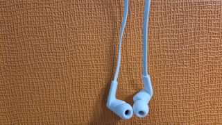 Belkin SoundForm Wired Earbuds with USB-C Connector against an orange background