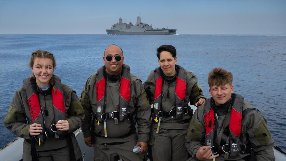 Four Naval helicopter pilots, who were not identified in this picture, stood in as the four crew members of Artemis 2 during a splashdown exercise on July 29, 2023. Like the astronauts, the pilots were brought from the capsule onto an inflatable "front porch" and then lifted into a helicopter for a journey to the flight deck of the U.S.S. John P. Murtha warship.