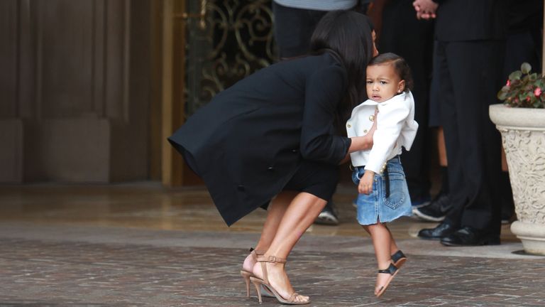 Kim Kardashian picks up young daughter North West.