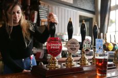 Barmaid pulling a pint of Fuller's London Pride