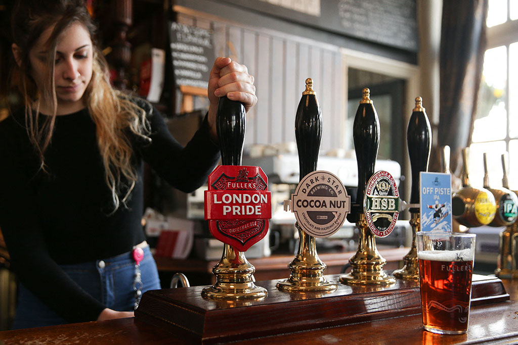 Barmaid pulling a pint of Fuller's London Pride