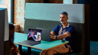 People sitting in booth with Dell XPS laptops on table