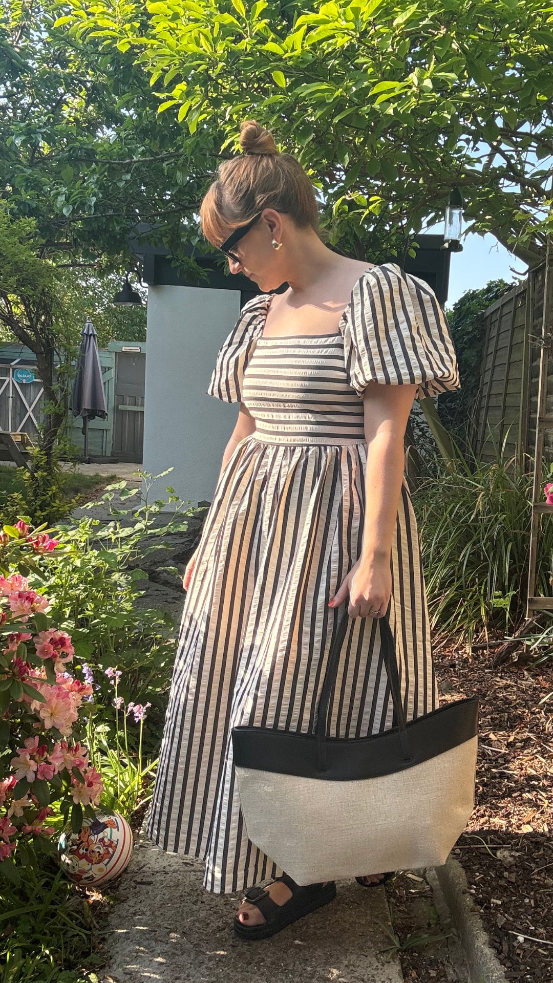 matilda wearing a striped dress and holding the TU tote bag