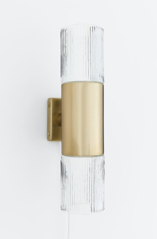 Slim vertical glass wall lamp with gold mount from H&M Home.