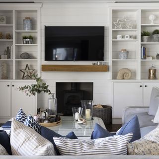 Beach-inspired living room with TV in middle of shelving units.