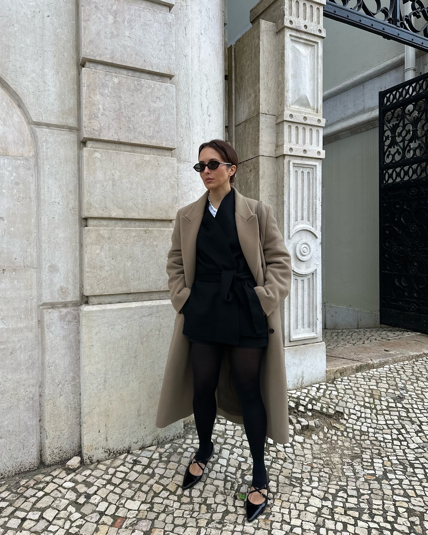 An image of @deborabrosa wearing a taupe trench coat with leggings and pointed-toe flats, one of the biggest winter trends to wear with leggings.